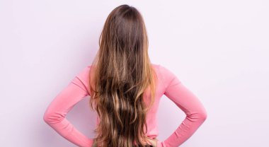 Asyalı güzel bir kadın kafası karışık ya da dolu ya da şüphe ve soru dolu, merak ediyor, elleri kalçasında, dikiz aynasından