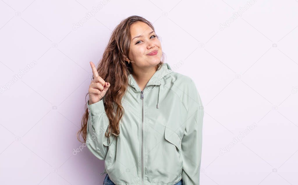 hispanic pretty woman feeling like a genius holding finger proudly up in the air after realizing a great idea, saying eureka