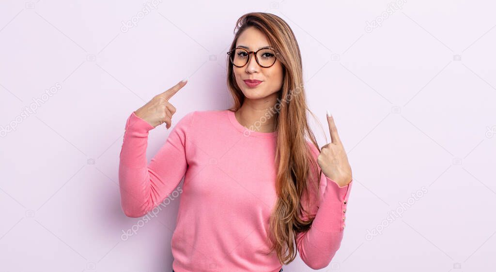 asian pretty woman with a bad attitude looking proud and aggressive, pointing upwards or making fun sign with hands