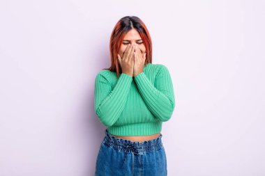 Genç İspanyol kadın mutlu, neşeli, şanslı ve şaşkın görünüyor. İki eliyle ağzını kapatıyor.