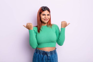 Genç İspanyol kadın neşeyle gülümsüyor ve mutlu görünüyor, kaygısız ve pozitif hissediyor.