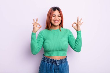 Genç İspanyol kadın konsantre olmuş ve meditasyon yapıyor, kendini tatmin olmuş ve rahatlamış hissediyor, düşünüyor ya da bir seçim yapıyor.