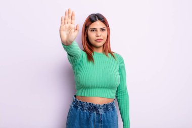 Genç İspanyol kadın ciddi, sert, hoşnutsuz ve kızgın görünüyor. Avuç içinin açık olması jesti durduruyor.