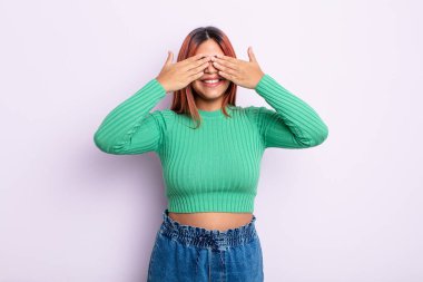 Genç İspanyol kadın gülümsüyor ve mutlu hissediyor, iki eliyle gözlerini kapatıyor ve inanılmaz bir sürpriz bekliyor.