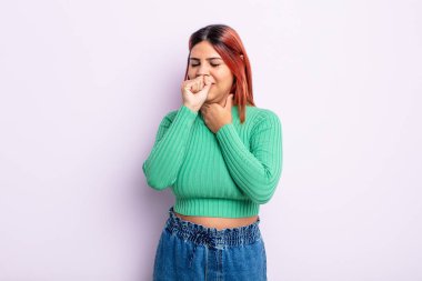 Boğazı ağrıyan ve grip belirtileri gösteren ağzı kapalı öksüren genç İspanyol kadın.