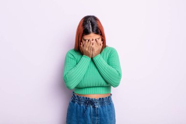 Genç İspanyol kadın üzgün, hayal kırıklığına uğramış, gergin ve depresif, iki eliyle yüzünü kaplayan, ağlayan