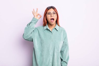 Genç İspanyol kadın kendini başarılı ve tatmin olmuş hissediyor, ağzı açık gülümsüyor, elle imza atıyor.