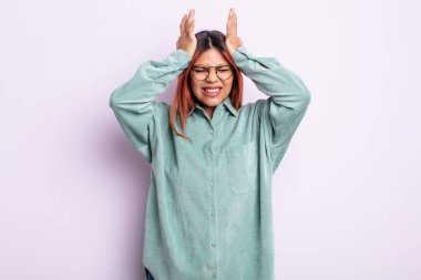 Genç İspanyol kadın stresli ve endişeli, depresif ve hayal kırıklığına uğramış hissediyor, iki elini de başa kaldırıyor.