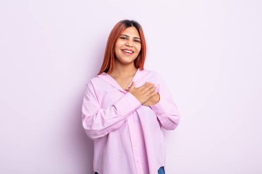 Genç İspanyol kadın romantik, mutlu ve aşık, neşeyle gülümsüyor ve kalbe yakın el ele tutuşuyor.