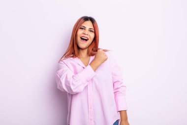 Genç İspanyol kadın mutlu, pozitif ve başarılı hissediyor, meydan okumayla karşılaştığında motive oluyor veya iyi sonuçları kutluyor.