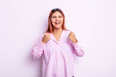 Genç İspanyol kadın zaferle bağırıyor, gülüyor, mutlu ve heyecanlı hissediyor başarıyı kutlarken.