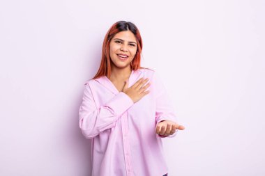 Genç İspanyol kadın kendini mutlu ve aşık hissediyor, bir eli kalbinin yanında gülümsüyor ve diğer eli önde uzanıyor.