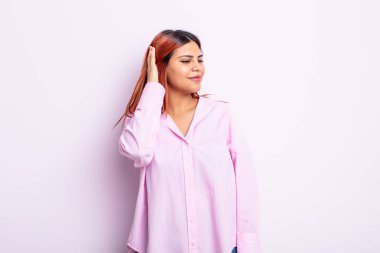 Genç İspanyol kadın neşeli ve sıradan bir şekilde gülümsüyor, olumlu, mutlu ve kendinden emin bir bakışla yumruk yumruğa.