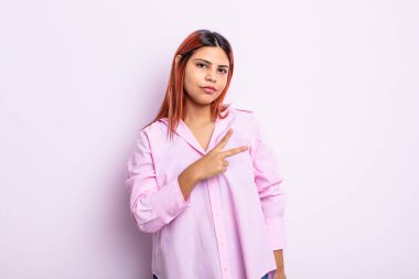 Genç İspanyol kadın kendini mutlu, pozitif ve başarılı hissediyor. Göğsünde el yapımı V ile zafer ya da huzur gösteriyor.