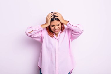 Genç İspanyol kadın kendini stresli ve hayal kırıklığına uğramış hissediyor. El ele tutuşuyor. Yorgun, mutsuz ve migren ağrısı çekiyor.