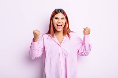 Genç İspanyol kadın mutlu, pozitif ve başarılı hissediyor, zaferi, başarıları veya iyi şansı kutluyor.