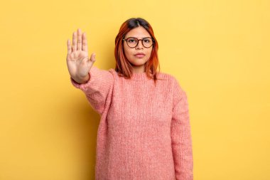 Genç İspanyol kadın ciddi, sert, hoşnutsuz ve kızgın görünüyor. Avuç içinin açık olması jesti durduruyor.