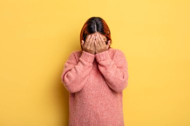 Genç İspanyol kadın üzgün, hayal kırıklığına uğramış, gergin ve depresif, iki eliyle yüzünü kaplayan, ağlayan