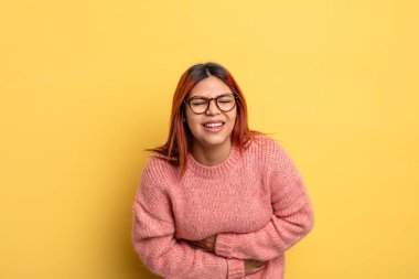 Genç İspanyol kadın endişeli, hasta, hasta ve mutsuz hissediyor. Ağrılı bir mide ağrısı ya da grip geçiriyor.