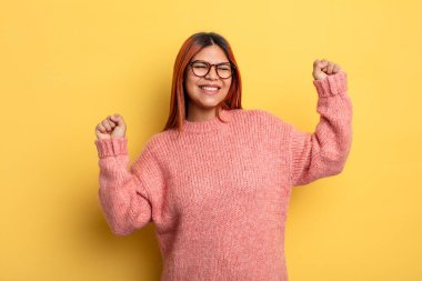 Genç İspanyol kadın son derece mutlu ve şaşırmış görünüyor, başarıyı kutluyor, bağırıyor ve zıplıyor.