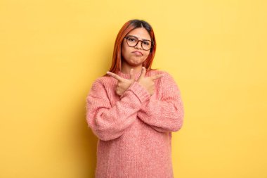 Genç İspanyol kadın şaşkın ve şaşkın görünüyor, güvensiz ve zıt yönlere şüpheyle bakıyor.