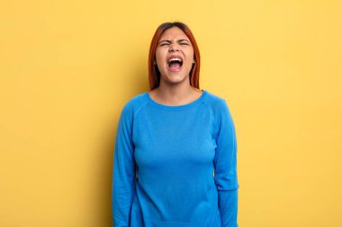 Genç İspanyol kadın agresif bir şekilde bağırıyor, çok kızgın, hayal kırıklığına uğramış, öfkeli ya da sinirli görünüyor, hayır diyor.
