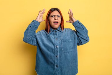 Genç İspanyol kadın ellerini havaya kaldırıp bağırıyor. Öfkeli, sinirli, stresli ve üzgün.