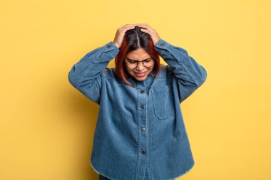 Genç İspanyol kadın kendini stresli ve hayal kırıklığına uğramış hissediyor. El ele tutuşuyor. Yorgun, mutsuz ve migren ağrısı çekiyor.