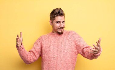 Genç yakışıklı adam mutlu, kibirli, gururlu ve kendinden memnun görünüyor. Kendini bir numara gibi hissediyor. Garip bıyık konsepti