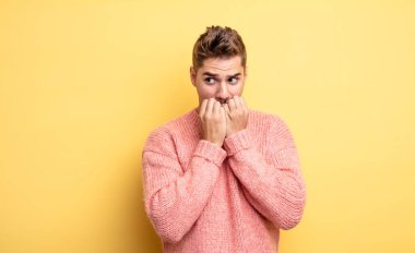 Genç yakışıklı adam endişeli, gergin, stresli ve korkmuş görünüyor tırnaklarını yiyor ve yanal fotokopi odasına bakıyor. Garip bıyık konsepti