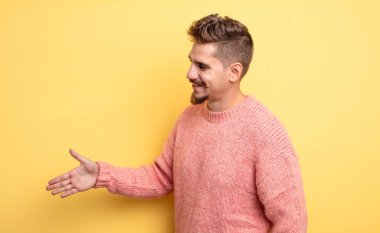 Genç yakışıklı adam gülümsüyor, seni selamlıyor ve başarılı bir anlaşma için el sıkışmayı teklif ediyor, işbirliği konsepti. Garip bıyık konsepti