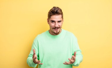 Genç yakışıklı adam kendini mutlu, şaşkın, şanslı ve şaşırmış hissediyor. - İnanılmaz. Garip bıyık konsepti