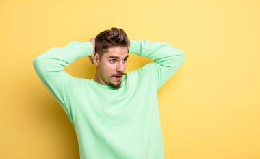 Genç ve yakışıklı bir adam, korkunç bir hata yüzünden dehşete düşmüş ve şok olmuş görünüyor, el ele tutuşuyor. Garip bıyık konsepti