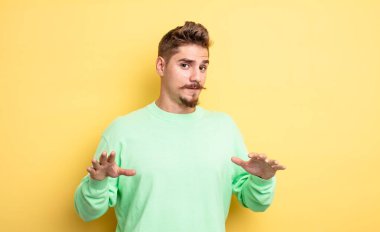 Genç yakışıklı adam gergin, endişeli ve endişeli görünüyor, benim hatam olmadığını yoksa benim yapmadığımı söylüyor. Garip bıyık konsepti 