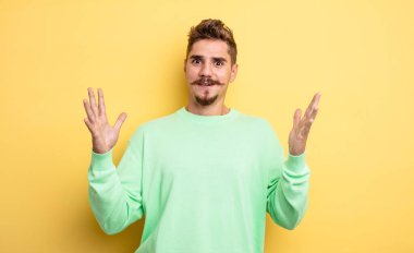 Genç yakışıklı adam şok olmuş ve şaşkın görünüyordu, inanılmaz bir şeyi fark ettiğinde ağzı açık kalmıştı. Garip bıyık konsepti