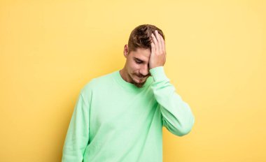 Genç yakışıklı adam gülüyor ve alnına şaplak atıyor. Unuttum ya da aptalca bir hataydı. Garip bıyık konsepti 