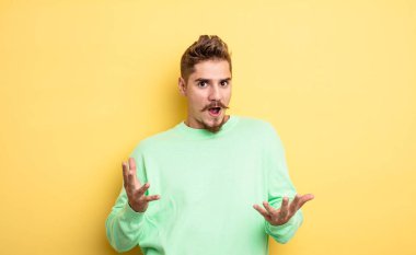 Genç yakışıklı adam ağzı açık ve şaşırmış, şok olmuş ve hayrete düşmüş inanılmaz bir sürprizle. Garip bıyık konsepti