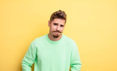 Genç ve yakışıklı bir adam üzgün ve mızmız, mutsuz bir bakışla, olumsuz ve hayal kırıklığına uğramış bir tavırla ağlıyor. Garip bıyık konsepti