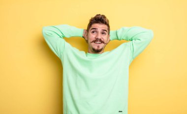 Genç yakışıklı adam mutlu, kaygısız, arkadaş canlısı ve rahat görünüyor. Hayattan ve başarıdan keyif alıyor, olumlu bir tavırla. Garip bıyık konsepti 