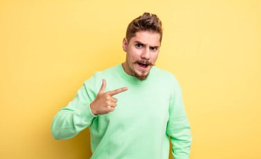 Kızgın agresif bir ifadeyle kameraya bakan genç, yakışıklı bir adam öfkeli, çılgın bir patron gibi görünüyor. Garip bıyık konsepti