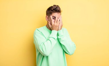 Genç ve yakışıklı bir adam korkmuş ya da utanmış hisseder. Gözleri yarı kapalı bir şekilde dikizler ya da gözetler. Garip bıyık konsepti