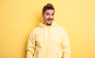 Genç yakışıklı adam mutlu ve hoş bir şekilde şaşırmış görünüyor. Büyülenmiş ve şok olmuş bir ifadeyle heyecanlanıyor. Garip bıyık konsepti