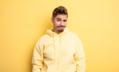 Genç yakışıklı bir adam kafası karışık ve şüpheli hissediyor, merak ediyor ya da karar vermeye çalışıyor. Garip bıyık konsepti