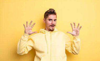Genç yakışıklı adam sersemlemiş ve korkmuş hissediyor. Korkutucu bir şeyden korkuyor. Elleri açık ve uzak dur diyor. Garip bıyık konsepti