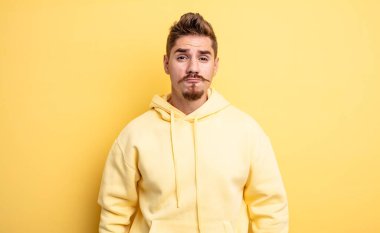 Genç yakışıklı adam dudaklarını birbirine bastırıyor, tatlı, eğlenceli, mutlu, sevimli bir yüz ifadesiyle, öpücük yolluyor. Garip bıyık konsepti