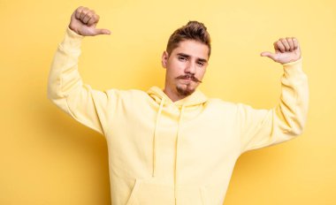 Genç yakışıklı, gururlu, kibirli ve kendinden emin, tatmin olmuş ve başarılı görünüyor, kendini işaret ediyor. Garip bıyık konsepti