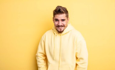 Genç ve yakışıklı bir adam neşeli, mutlu, kendinden emin ve rahat bir ifadeyle gülümsüyor. Garip bıyık konsepti