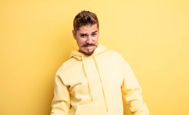 Genç yakışıklı adam kendini cahil, kafası karışık ve hangi seçeneği seçeceği konusunda kararsız hissediyor. Sorunu çözmeye çalışıyor. Garip bıyık konsepti