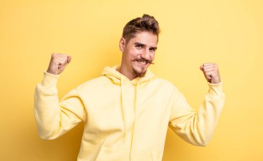 Genç yakışıklı adam mutlu, pozitif ve başarılı hissediyor, zaferi, başarıları ya da iyi şansı kutluyor. Garip bıyık konsepti