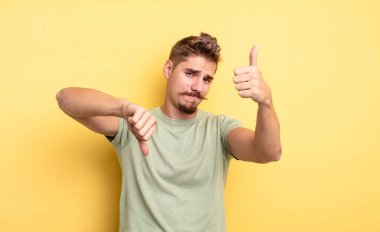 Genç yakışıklı, kafası karışmış, bilgisiz ve emin olmayan farklı seçenekler ve seçeneklerle iyiyi ve kötüyü tartıyor. Garip bıyık konsepti